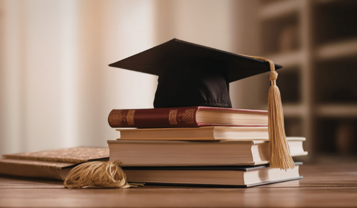 a mortar board sitting on top of a pile of books