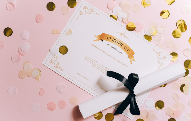 A certificate and a rolled up piece of paper tied with a ribbon